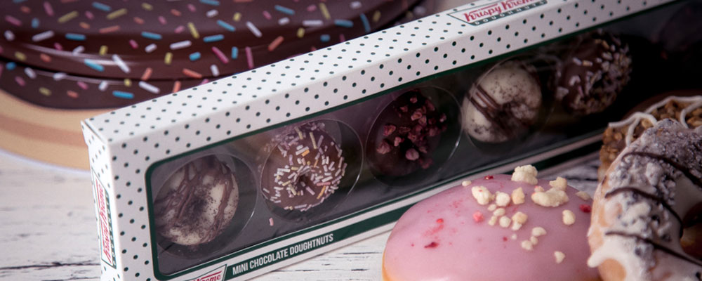 Mini chocolate doughnut selection gift box with Krispy Kreme gift tin in the background